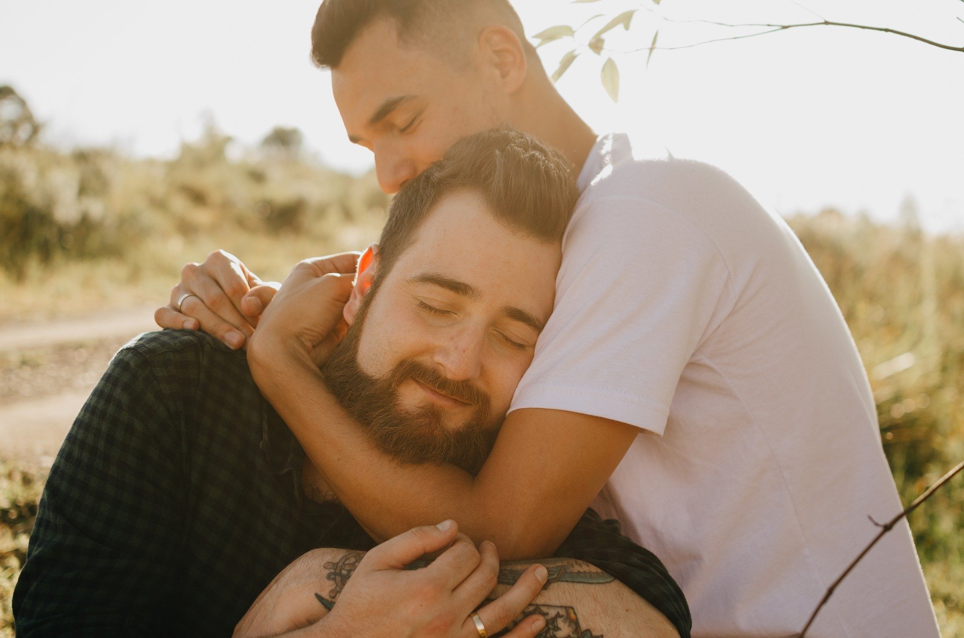 Image of two men having a clearly gay snuggle.